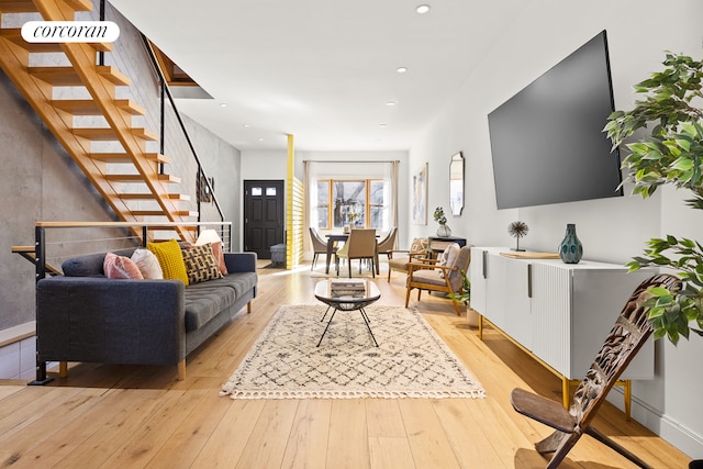 living area featuring light wood finished floors, stairway, and recessed lighting