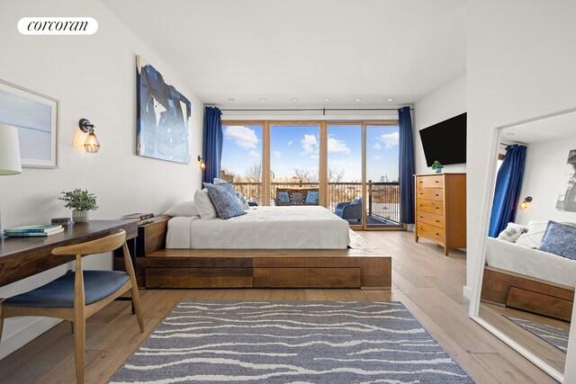 bedroom with wood finished floors, visible vents, and access to exterior