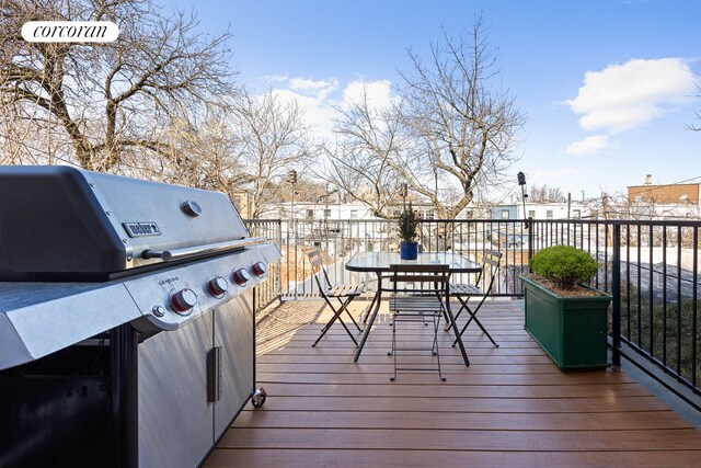 wooden terrace with grilling area and outdoor dining area