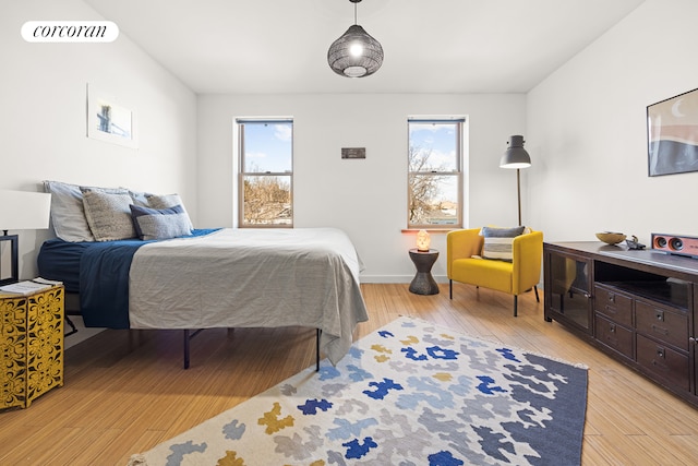 bedroom featuring light wood-style floors, baseboards, multiple windows, and visible vents