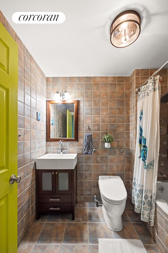 bathroom featuring toilet, tiled shower / bath, tile walls, and vanity