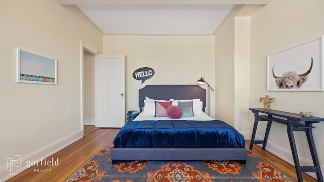 bedroom featuring baseboards and wood finished floors