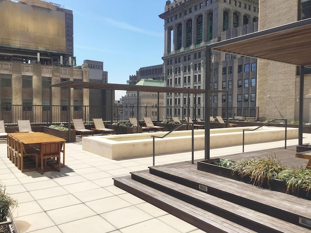 view of patio featuring a view of city and fence