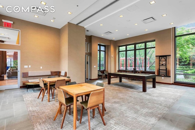 playroom with a towering ceiling, billiards table, recessed lighting, and stone tile flooring