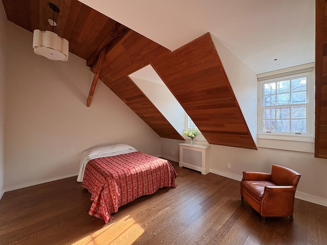 bedroom featuring lofted ceiling with beams, baseboards, and wood finished floors