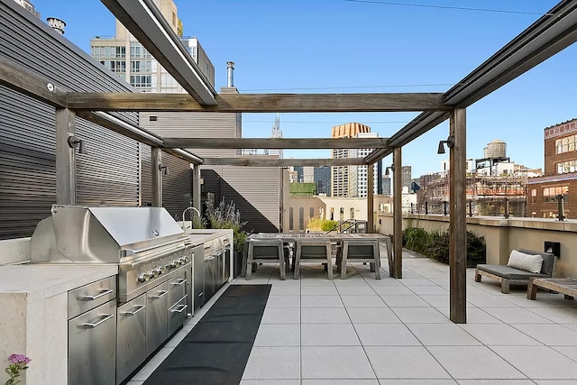 view of patio / terrace featuring outdoor dining space, exterior kitchen, area for grilling, and a city view