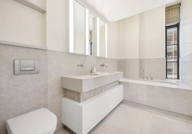 bathroom with tile walls, tile patterned floors, toilet, and double vanity