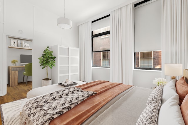 bedroom with radiator heating unit and wood finished floors