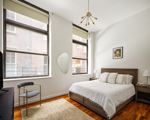 100 Reade St Unit 2A, New York City, NY 10013 - bedroom with multiple windows, wood finished floors, and a notable chandelier