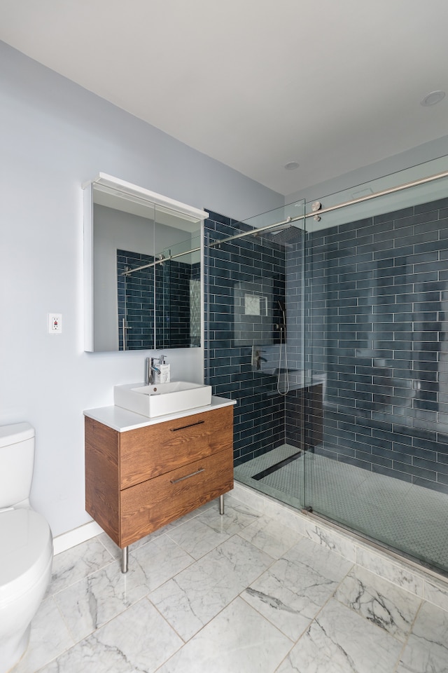 full bathroom with marble finish floor, toilet, vanity, a shower stall, and baseboards