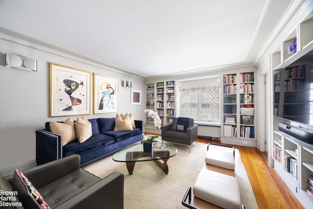 living area featuring radiator heating unit, wood finished floors, and crown molding