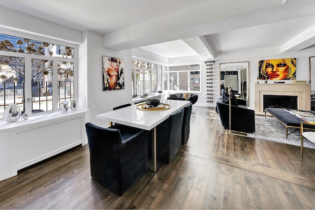 kitchen with a fireplace, dark wood-type flooring, beamed ceiling, open floor plan, and a center island