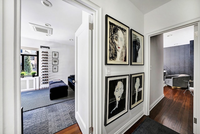 hallway featuring wood finished floors and visible vents