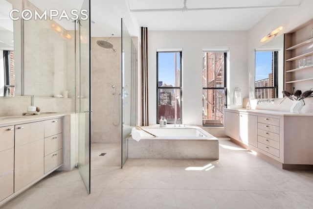 bathroom with tile patterned floors, a walk in shower, vanity, and a garden tub