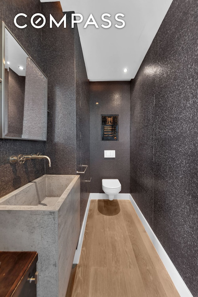 bathroom featuring vanity, toilet, wood finished floors, and baseboards