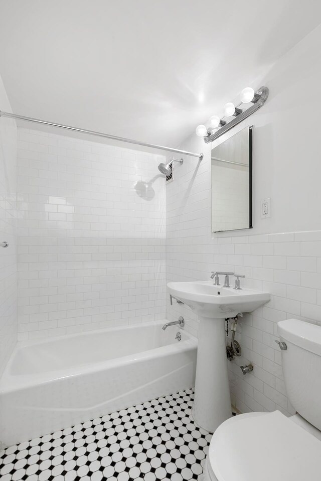 321 E 48th St Unit 5L, New York City, NY 10017 - bathroom with toilet, tile patterned floors, tile walls, and shower / bath combination