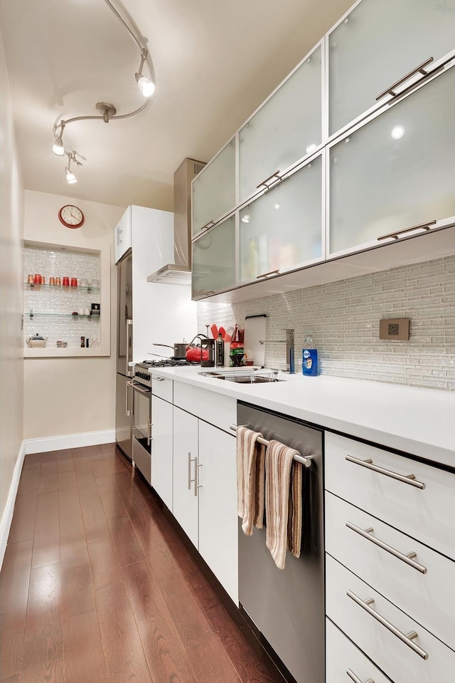 kitchen featuring decorative backsplash, light countertops, wall chimney range hood, and stainless steel appliances