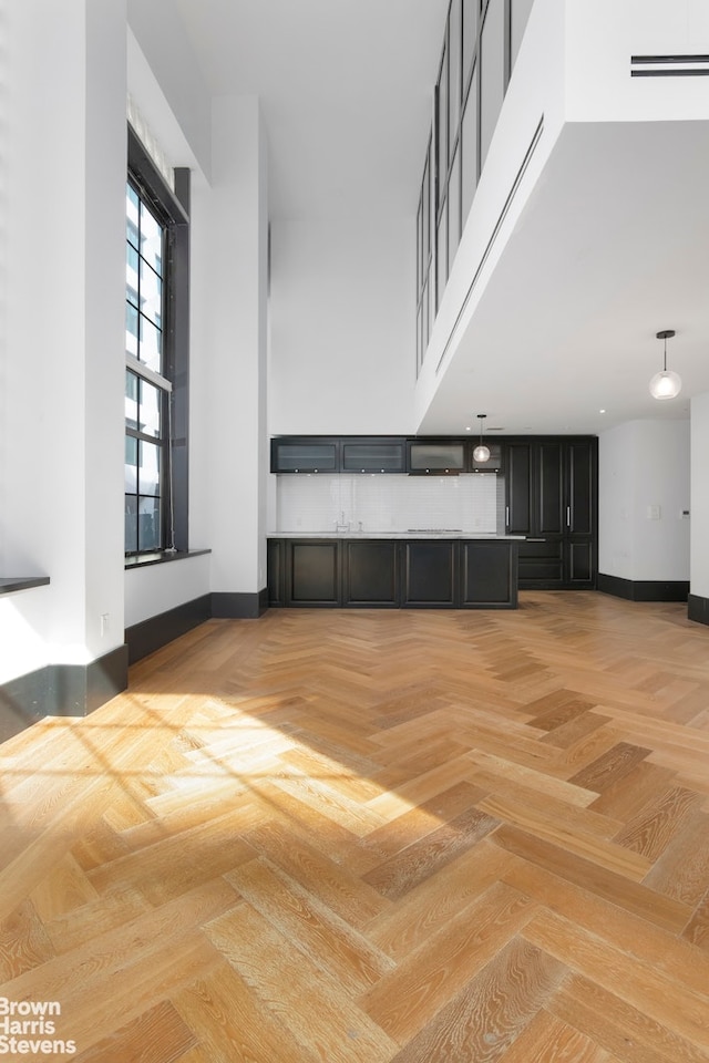 unfurnished living room featuring a high ceiling and baseboards