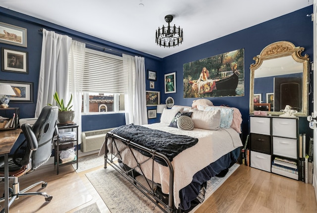 bedroom with wood finished floors and a notable chandelier