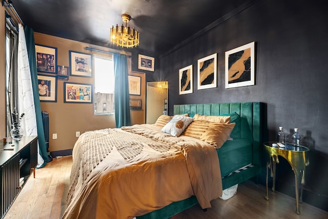 bedroom with crown molding and wood finished floors