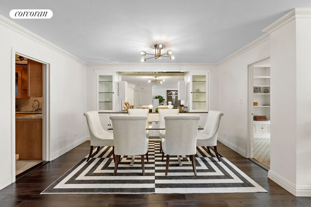 dining space featuring crown molding, a notable chandelier, baseboards, dark wood-type flooring, and visible vents
