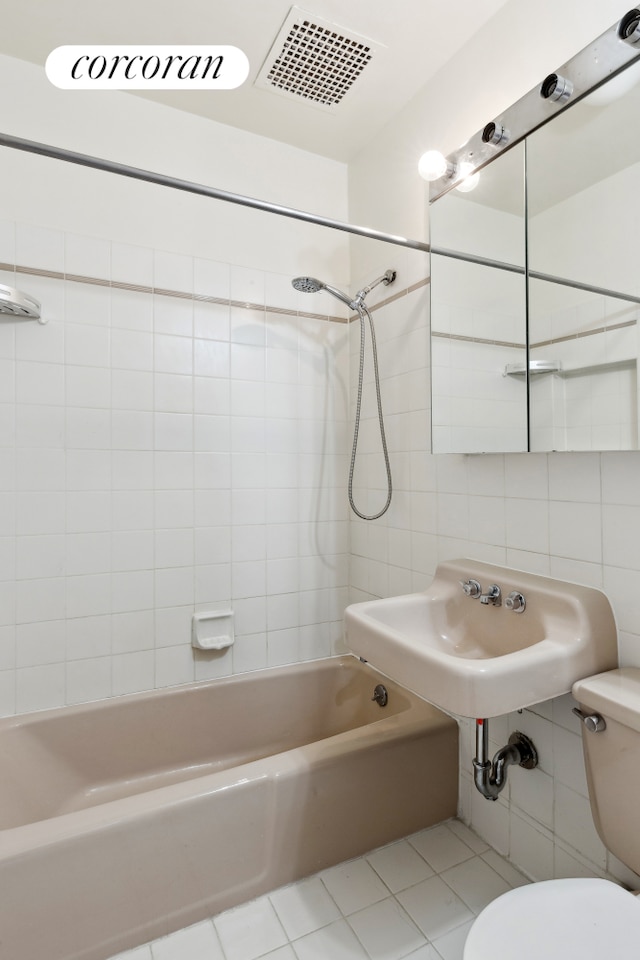 117 W 87th St, New York City, NY 10024 - full bathroom featuring tile walls, bathtub / shower combination, toilet, and tile patterned floors