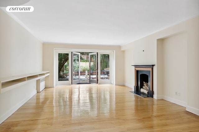 unfurnished living room with light wood finished floors, visible vents, baseboards, ornamental molding, and a fireplace