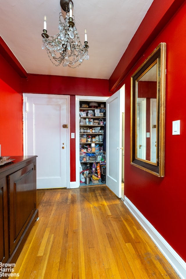 414 E 52nd St Unit 10E, New York City, NY 10022 - entryway with wood-type flooring, a chandelier, and baseboards