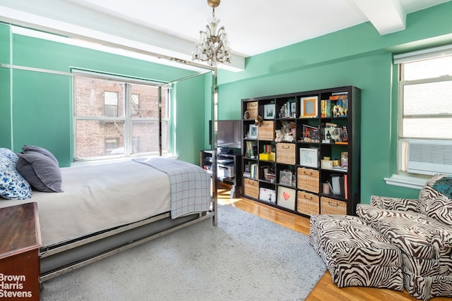 414 E 52nd St Unit 10E, New York City, NY 10022 - bedroom featuring a chandelier, wood finished floors, and cooling unit