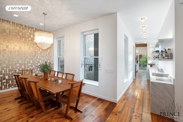 dining space featuring visible vents, baseboards, hardwood / wood-style floors, and a chandelier