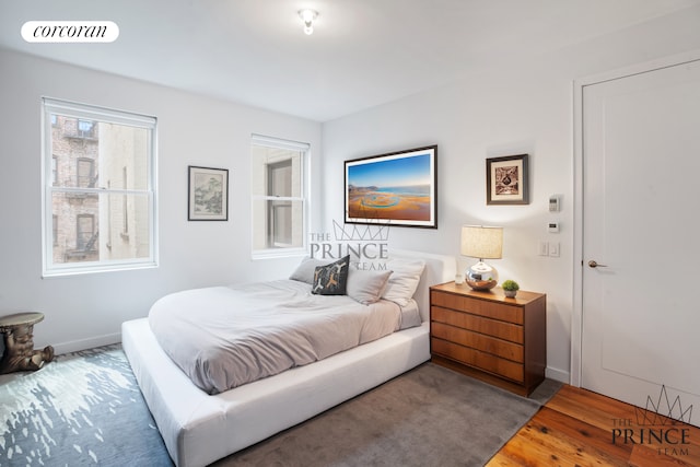 bedroom with visible vents, baseboards, and wood finished floors