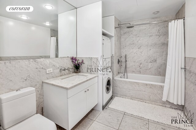 full bath featuring visible vents, tiled shower / bath, toilet, stacked washer / dryer, and vanity