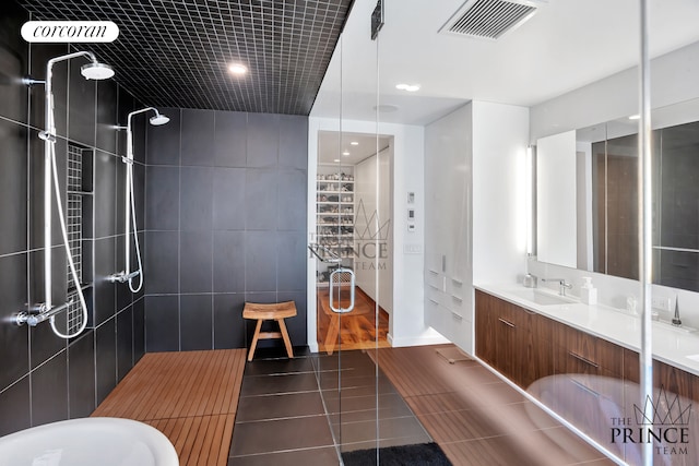 full bathroom with a sink, visible vents, double vanity, and a walk in shower