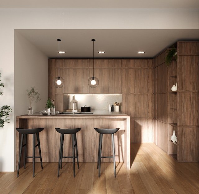 bar with hanging light fixtures and wood finished floors