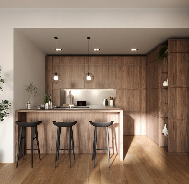 28 Herbert St Unit 4C, New York City, NY 11222 - kitchen with modern cabinets, wood finished floors, a peninsula, a kitchen breakfast bar, and recessed lighting