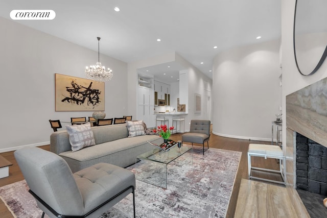 living area featuring visible vents, baseboards, recessed lighting, a fireplace, and wood finished floors