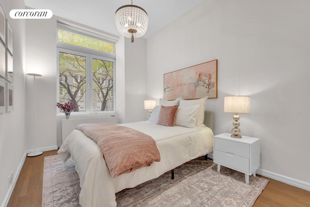 30 W 86th St Unit 2B, New York City, NY 10024 - bedroom featuring wood finished floors, a chandelier, and radiator heating unit