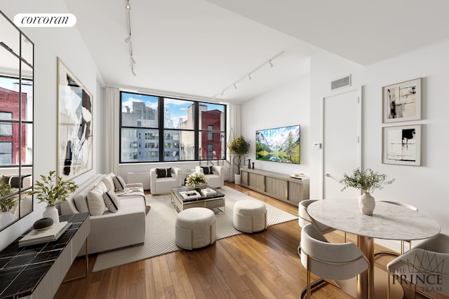 living area featuring visible vents, hardwood / wood-style floors, and rail lighting