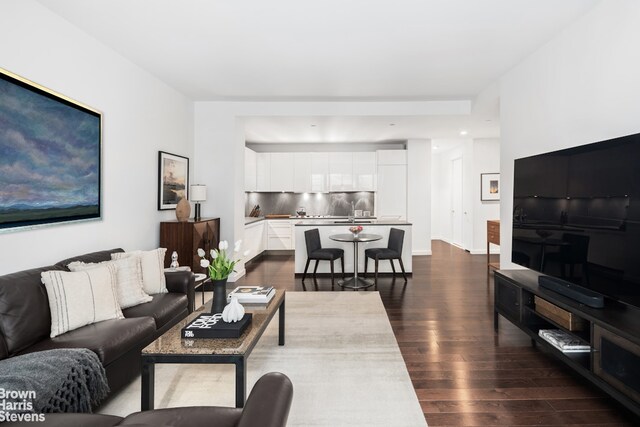 kitchen featuring dark countertops, modern cabinets, stainless steel microwave, and a sink