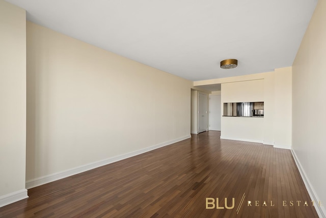 unfurnished living room with baseboards and dark wood-style flooring