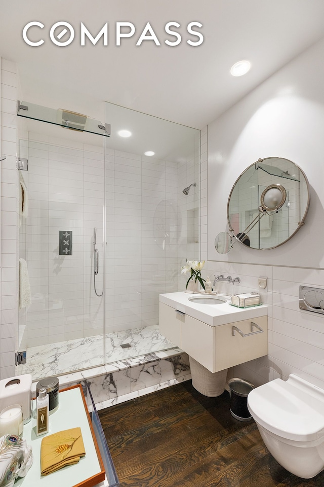 110 E 71st St Unit 3, New York City, NY 10021 - bathroom featuring a stall shower, tile walls, toilet, wood finished floors, and recessed lighting