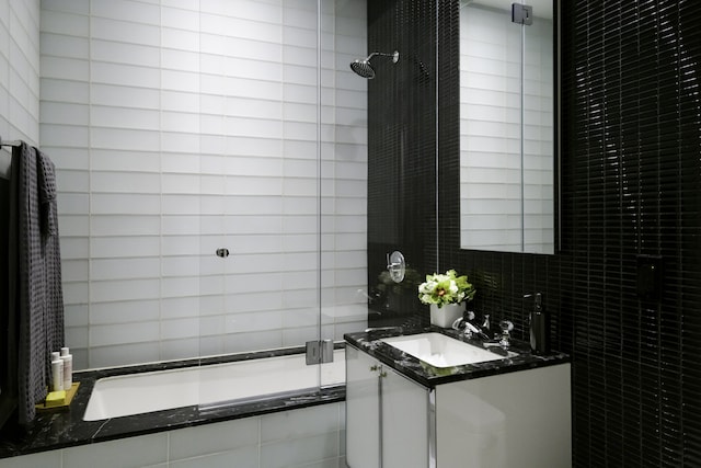 bathroom featuring vanity, tile walls, and tiled shower / bath