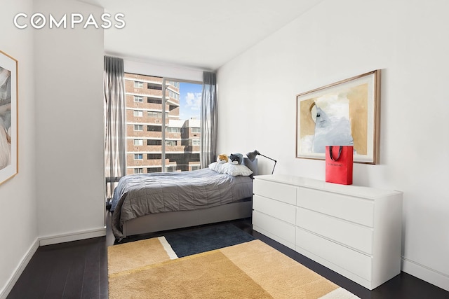 bedroom with baseboards and wood finished floors