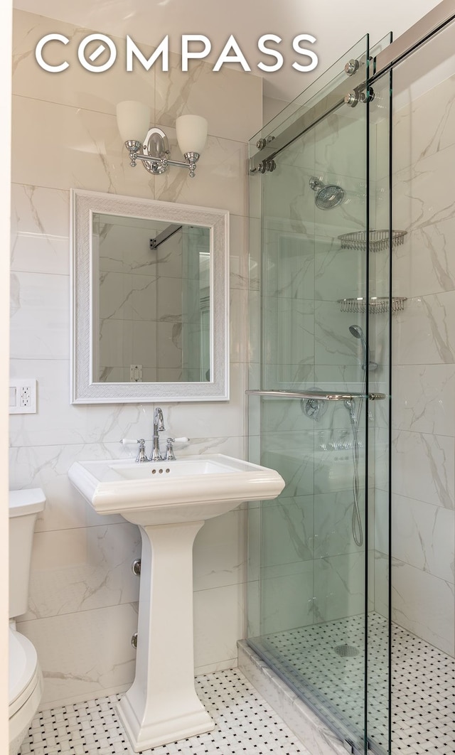 132 E 35th St Unit 7H, New York City, NY 10016 - bathroom with toilet, a shower stall, tile walls, and a sink