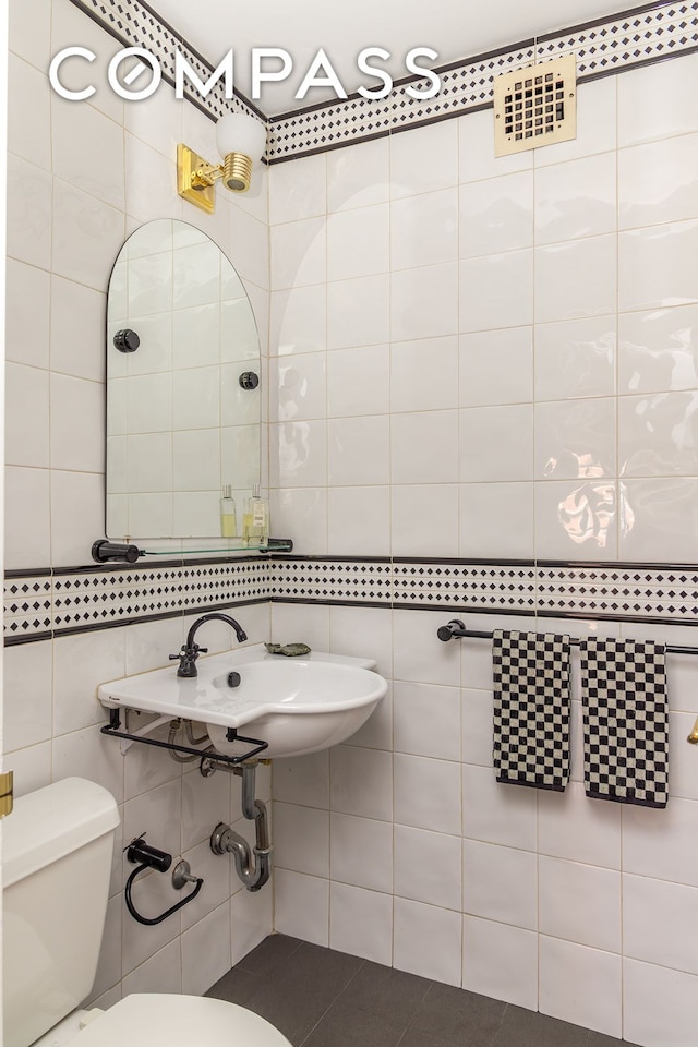 132 E 35th St Unit 7H, New York City, NY 10016 - bathroom with tile walls, toilet, and a sink