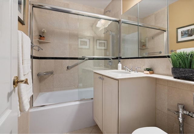 bathroom with tile patterned flooring, vanity, toilet, and bath / shower combo with glass door