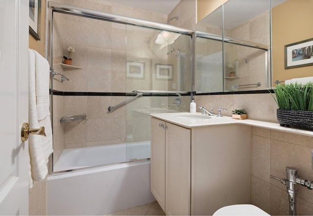 bathroom featuring shower / bath combination with glass door, tile patterned flooring, vanity, toilet, and decorative backsplash