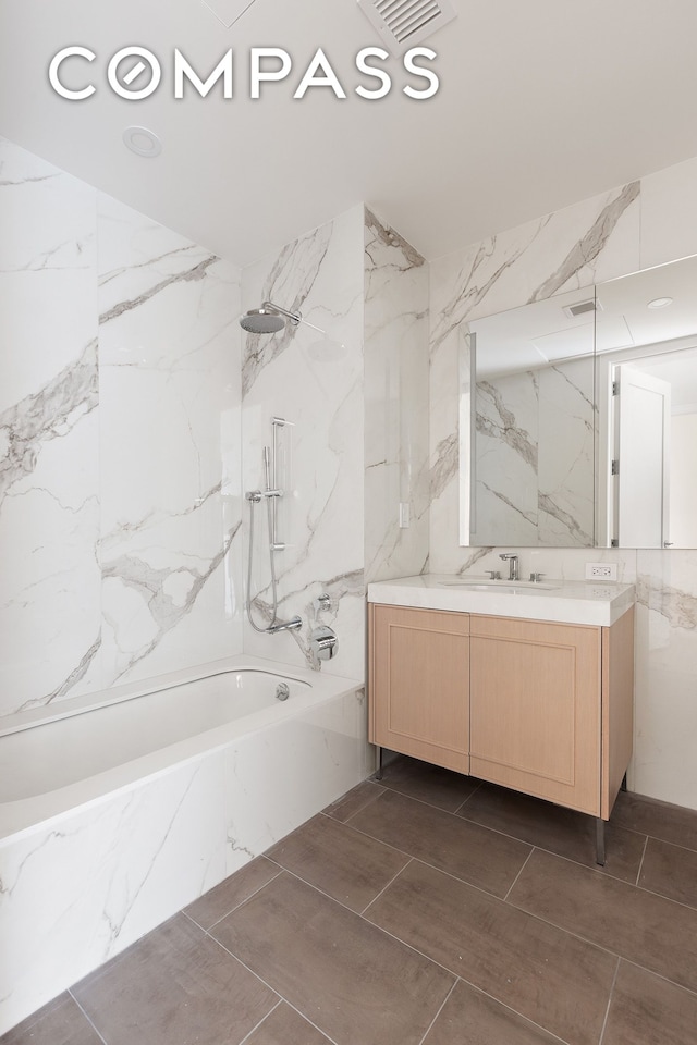 full bath with tile walls, stone wall, vanity, and a combined bath / shower with marble appearance