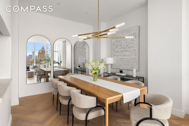 dining area featuring a notable chandelier and baseboards