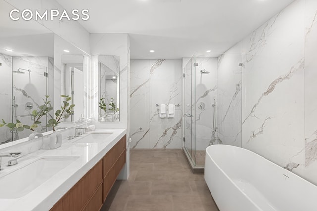 bathroom with a marble finish shower, stone wall, and a sink